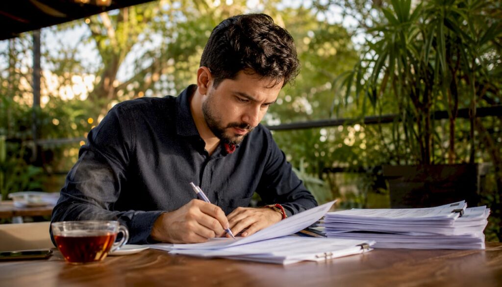 Profissional revisando documentos trabalhistas em um escritório de engenharia civil
