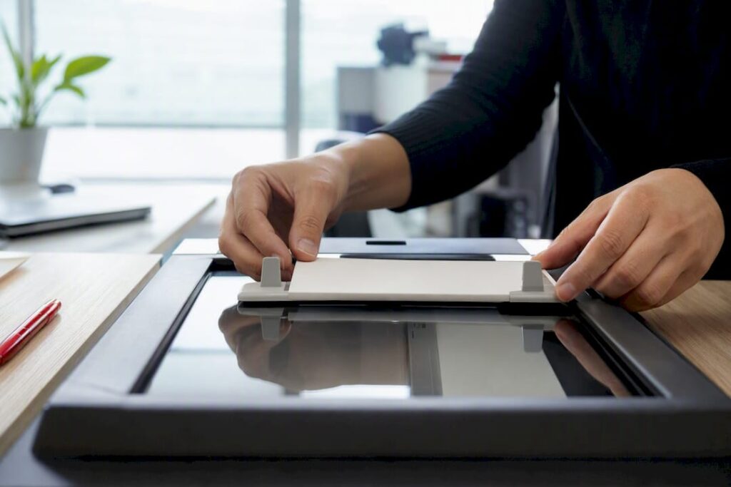Mãos ajustando scanner para digitalizar documentos